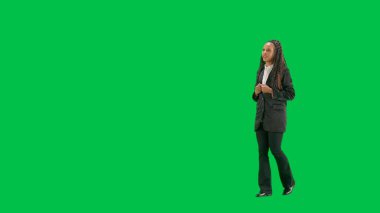 Televizyon haberleri ve canlı yayın konsepti. Genç bayan muhabir krom anahtar yeşil ekran arka planında izole edildi. Tam teşekküllü Afro-Amerikan kadın televizyon sunucusu yürüyüp konuşuyor. Yarım dönüş..