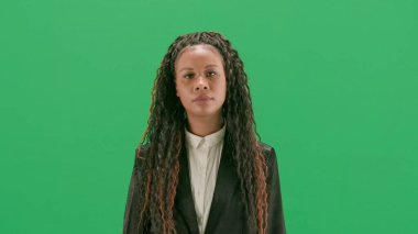 Televizyon haberleri ve canlı yayın konsepti. Genç bayan muhabir krom anahtar yeşil ekran arka planında izole edildi. Afrikalı Amerikalı kadın TV haber sunucusu yürüyor.