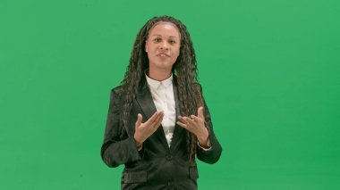 Televizyon haberleri ve canlı yayın konsepti. Genç bayan muhabir krom anahtar yeşil ekran arka planında izole edildi. Afrikalı Amerikalı kadın TV sunucusu kameraya bakarak konuşuyor..