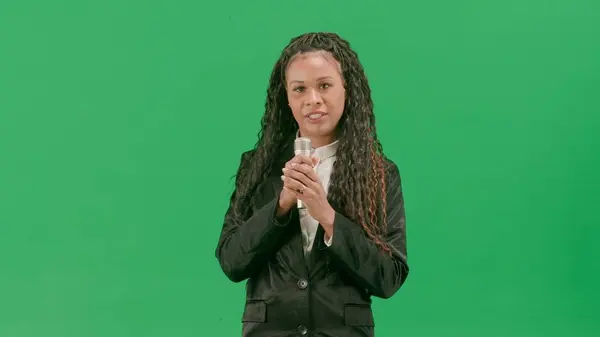 テレビニュースとライブ放送コンセプト クロマキーの緑色の背景に隔離された若い女性の記者は アフリカ系アメリカ人女性テレビニュースホスト マイクで話す — ストック写真