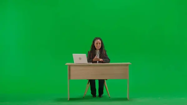 テレビニュースとライブ放送コンセプト クロマキーの緑色の背景に隔離された机の女性の記者 フルショット アフリカ系アメリカ人女性テレビニュースホスト カメラで話している — ストック写真