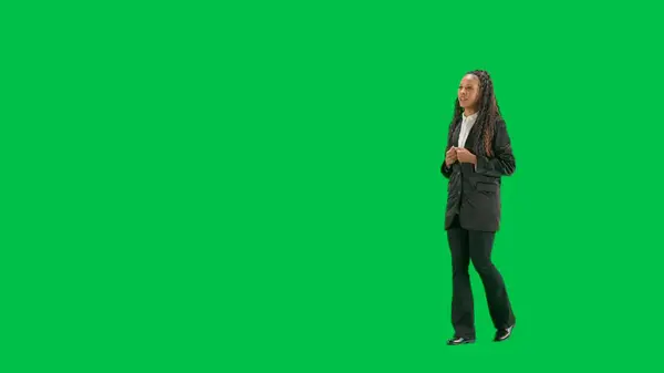 电视新闻和现场直播的概念 年轻的女记者在彩色键绿色屏幕背景上被隔离 全镜头非洲裔美国妇女电视新闻节目主持人走路和说话 转半圈 — 图库照片