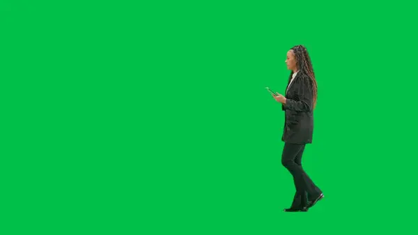 テレビニュースとライブ放送コンセプト クロマキーの緑色の背景に隔離された若い女性の記者は アフリカ系アメリカ人女性テレビのニュースホストがタブレットを持ち歩き サイドビュー — ストック写真