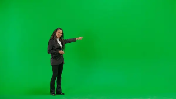 テレビニュースとライブ放送コンセプト クロマキーの緑色の背景に隔離された若い女性の記者は フルショットアフリカ系アメリカ人女性テレビニュースホスト カメラで笑顔 — ストック写真