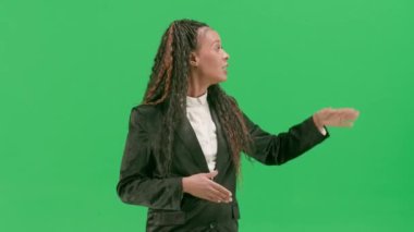 Televizyon haberleri ve canlı yayın konsepti. Genç bayan muhabir krom anahtar yeşil ekran arka planında izole edildi. Afrikalı Amerikalı kadın TV sunucusu kameraya bakarak konuşuyor..