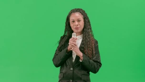 电视新闻和现场直播的概念 年轻的女记者在彩色键绿色屏幕背景上被隔离 非裔美国妇女电视新闻节目主持人用话筒讲话 — 图库视频影像