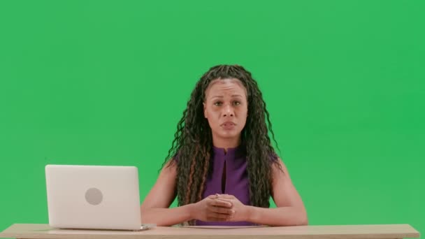 テレビニュースとライブ放送コンセプト ドレスの女性は クロマキーグリーンスクリーンの背景に隔離された机に座ります アフリカ系アメリカ人女性テレビニュースホスト座ってカメラを見ている — ストック動画