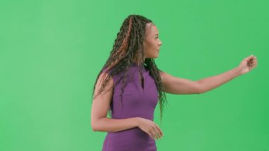 Televizyon haberleri ve canlı yayın konsepti. Krom anahtar yeşil ekran arka planında izole edilmiş bir kadın. Afrika kökenli Amerikalı kadın TV sunucusu kameraya bakarak konuşuyor..