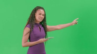 Televizyon haberleri ve canlı yayın konsepti. Krom anahtar yeşil ekran arka planında izole edilmiş bir kadın. Afrika kökenli Amerikalı kadın TV sunucusu kameraya bakarak konuşuyor..