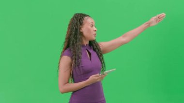 Televizyon haberleri ve canlı yayın konsepti. Krom anahtar yeşil ekran arka planında izole edilmiş bir kadın. Afrika kökenli Amerikalı kadın TV sunucusu kameraya bakarak konuşuyor..