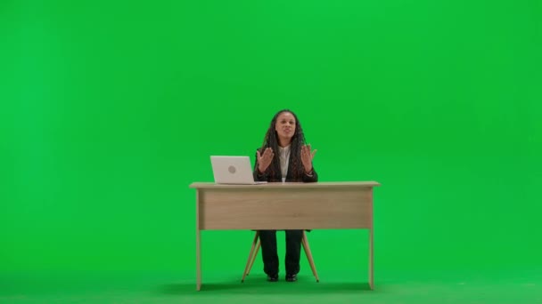 电视新闻和现场直播的概念 女性记者在办公桌上被隔离在彩色键绿色屏幕背景上 全镜头非洲裔美国妇女电视新闻节目主持人坐在摄像机前交谈 — 图库视频影像