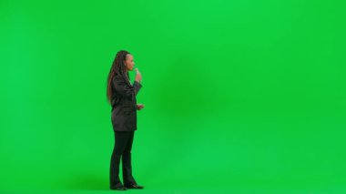 Televizyon haberleri ve canlı yayın konsepti. Genç bayan muhabir krom anahtar yeşil ekran arka planında izole edildi. Tam teşekküllü Afro-Amerikan kadın TV sunucusu mikrofon kullanarak röportaj yapıyor..