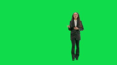 Televizyon haberleri ve canlı yayın konsepti. Genç bayan muhabir krom anahtar yeşil ekran arka planında izole edildi. Tam teşekküllü Afro-Amerikan kadın TV sunucusu yürüyor ve konuşuyor..