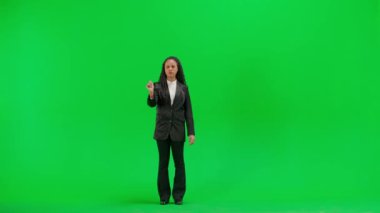 Televizyon haberleri ve canlı yayın konsepti. Genç bayan muhabir krom anahtar yeşil ekran arka planında izole edildi. Tam teşekküllü Afro-Amerikan kadın televizyon sunucusu sanal ekran kullanıyor..