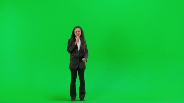 电视新闻和现场直播的概念 年轻的女记者在彩色键绿色屏幕背景上被隔离 全镜头非洲裔美国妇女电视新闻节目主持人讲话筒 — 图库视频影像