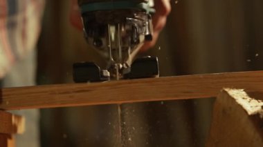 Marangozluk ve el işi reklam konsepti. Garajda çalışan erkek marangoz. Yapboz kullanarak atölyede ahşap malzemelerle çalışan profesyonel marangoz uzmanı..