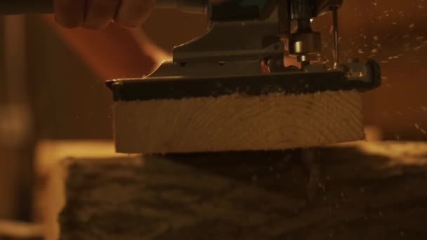 カルペントリーと手工芸の広告コンセプト ガレージで働いている男性の木工労働者 ジグソーを使用してワークショップで木材材料を扱う人間の専門の大工のスペシャリスト ショットを閉じる — ストック動画