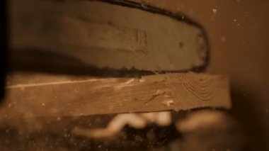 Marangozluk ve el işi reklam konsepti. Garajda çalışan erkek marangoz. Profesyonel marangoz, atölyede elektrikli testere kullanarak ahşap kesiyor..