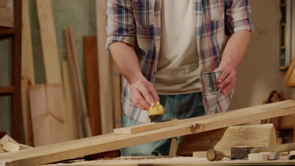 수공예 차고에서 Woodworker 얼룩을 판자를 적시는 작업장에 나무로 물자를 사용하는 스톡 비디오