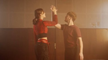 Deneysel koreografi dans stili konsepti. Profesyonel dansçılar dans gösterisi yapıyor. Genç erkek ve kadın dansçılar modern koreografi elementlerini dumanla, orta çekimde sergiliyorlar..