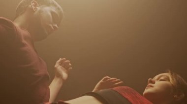 Deneysel koreografi dans stili konsepti. Profesyonel dansçılar dans gösterisi yapıyor. Genç erkek ve kadın modern dansçılar duman içinde modern koreografi öğeleri sergiliyorlar..