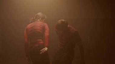 Deneysel koreografi dans stili konsepti. Profesyonel dansçılar dans gösterisi yapıyor. Genç erkek ve kadın dansçılar modern koreografi elementlerini dumanla, orta çekimde sergiliyorlar..