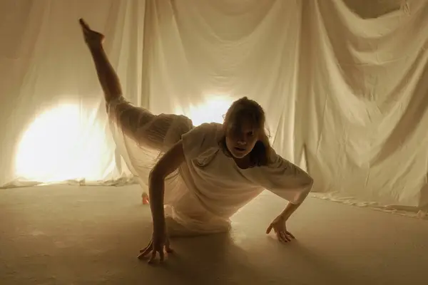 Silueta Una Bailarina Bailando Suelo Sobre Fondo Claro Capturada Movimiento —  Fotos de Stock
