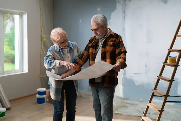 Engrossed Discussion Elderly Couple Examines House Plans Renovation Project — Stock Photo, Image