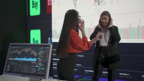 金融企業のビジネスコンセプト オフィスで成功した人たち 取引を祝う株式を販売するヘッドセットで話す大きな画面の前にブローカー 幸せな表現勝利ジェスチャー — ストック動画