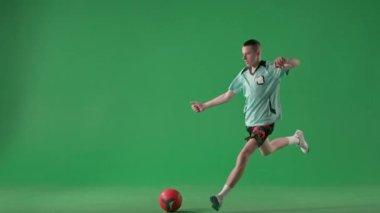 Krom anahtar yeşil ekran arka planında spor reklamı konsepti. Profesyonel futbolcu grev yapıyor ve galibiyeti kutluyor.