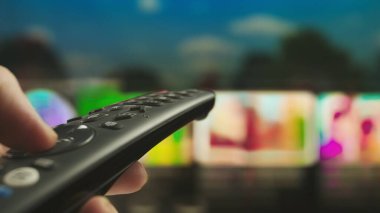Uzaktan kumandalı kadın. Uzaktan kumandalı kanal değiştiren kadın, akıllı TV teknolojisi internet içeriği, arka planda içeriği yakın plan çekiminde olan ekran.