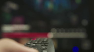 Uzaktan kumandalı kadın. Uzaktan kumandalı kanal değiştiren kadın, akıllı TV teknolojisi internet video içeriği, arka planda ortam içeriği olan ekran yakın plan çekimi.