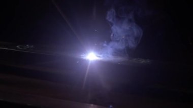 Kaynak makinesi, metal ürünler üzerinde çalışıyor. Yakın çekim. Demir yüzeyde kaynak makinesi kullanan metal işçisi, kıvılcımlar ve yanıp sönen ışıklar koyu arkaplan, çelik kaynak yapan insan işçisi..