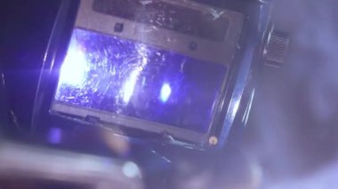 Kaynak makinesi, metal ürünler üzerinde çalışıyor. Yakın çekim. Demir yüzeyde kaynak makinesi kullanan metal işçisi, duman, kıvılcımlar ve yanıp sönen ışıklar, maske takan çelik malzeme işçisi..