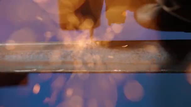 工人使用磨床切割钢料 在工厂与磨床一起工作的工匠 磨铁料的人 在黑暗的车间里飞来飞去的火花 落在地上 — 图库视频影像
