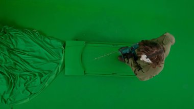 Hokey maskeli ve tulumlu bir manyak elinde testere ile yürüyüp etrafa bakıyor. Korkunç Jason Voorhees 'deki tanınmayan adam yeşil ekran kromatonunda görünüyor. Cadılar Bayramı, korku manzarası.