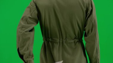 Arkasına bıçak saklayan bir manyağın dikiz görüntüsü. Tulumlu, yeşil ekran krom düğmeli silahlı bir adam yaklaşıyor. Cadılar Bayramı, korku