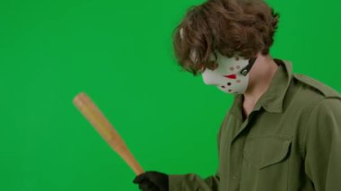 Hokey maskeli ve tulumlu bir manyak ahşap bir beyzbol sopasına doğrudan kameraya vuruyor. Korkunç Jason Voorhees 'deki tanınmayan adam yeşil ekran krom anahtarında görünüyor. Cadılar Bayramı, korku