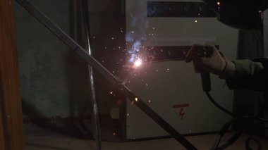 Metal ürün üzerinde çalışan kaynak makinesi. Demir yüzeyde kaynak makinesi, duman, kıvılcım ve yanıp sönen ışıklar kullanan metal işçisi, çelik kaynak yapan insan işçisi..