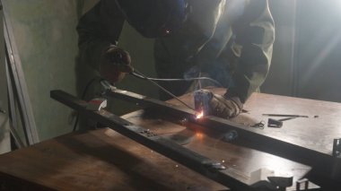 Metal ürün üzerinde çalışan kaynak makinesi. Demir yüzeyde kaynak makinesi, duman, kıvılcım ve yanıp sönen ışıklar kullanan metal işçisi, çelik kaynak yapan insan işçisi..