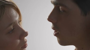 Genç erkek ve kadın şefkatli yüzler birbirlerine bakarken vurulurlar, tutku dokunuşu, samimi duygular. Aşk ve sevgi ilişkileri kavramı. Sevgili çift stüdyoda yakın çekim yapıyor..
