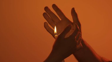 Genç erkek ve kadın şefkatli aşıklar, tutku mahremiyeti, eller mum alevi, cazibe ve arzuya dokunuyor. Aşk ve sevgi ilişkileri kavramı. Sevgili çift stüdyoda yakın çekim yapıyor..