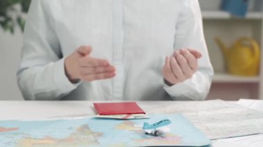 Pasaport ve biletleri erkek bir müşteriye veren bir kadın seyahat acentesinin yakın çekimi. Seyahat acentesi ve müvekkil, minnettarlık göstergesi olarak el sıkışıyorlar. Tur rezervasyonu ile ilgili bir işlemin tamamlanması.