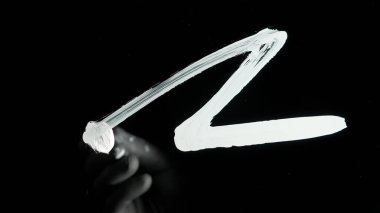 Sanatçı şeffaf cam yüzeyde çizim yapar. Akrilik yağlı orta boyalı büyük fırça kullanan ve doğrudan siyah cam ekran izole arka plan üzerinde çizim yapan kişi, zıt görüş sahnesi.