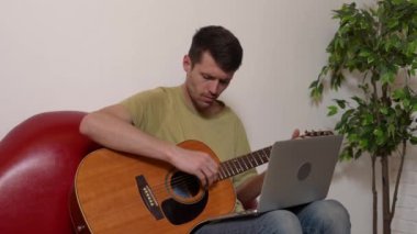 Evde gitar çalan genç bir müzisyen. Yetişkin bir gitarist odada oturmuş akustik gitar çalıyor. İnternette dizüstü bilgisayar öğrenme dersleri alıyor. Hobi ve boş zaman kavramı.