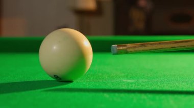 Hobi ve eğlence konsepti. Lüks bilardo kulübü sahnesi. Rus bilardo masasının beyaz topa vuruşunu yakın çekimde çek. Biri topa sahneden uzağa vuruyor..