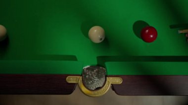 Hobi ve eğlence konsepti. Lüks bilardo kulübü sahnesi. Rus bilardo masasının üst görüntüsü. Ağ cebi ve içine düşen beyaz top. İnsan deliğin içindeki topa vuruyor..