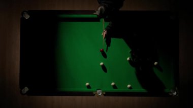 Hobi ve eğlence konsepti. Lüks bilardo kulübü sahnesi. Rus bilardo masasının üst görüntüsü net cebi ve içine düşen beyaz top, deliğin içindeki topa vuran kişi..