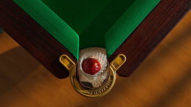 Hobi ve eğlence konsepti. Lüks bilardo kulübü sahnesi. Rus bilardo masasının üst görüntüsü. Ağ cebi ve içine düşen kırmızı top. Deliğin içindeki topa vuran kişi..