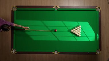 Hobi ve eğlence konsepti. Lüks bilardo kulübü sahnesi. Rus bilardo masasının tam görüntüsü kırmızı topa vurulan beyaz toplar, top piramidine bilardo sopasıyla vuran kişi..